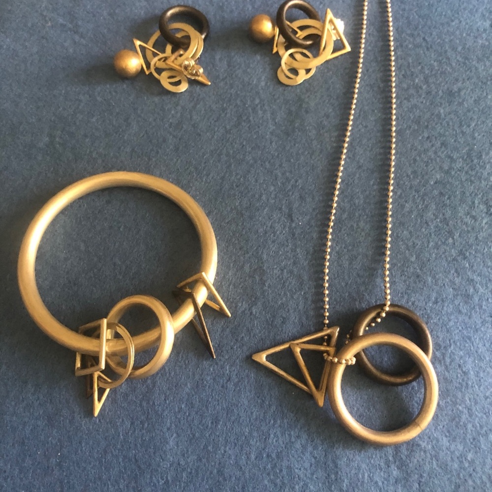 Necklace, earrings and bangle with free-floating geometric shapes as charms